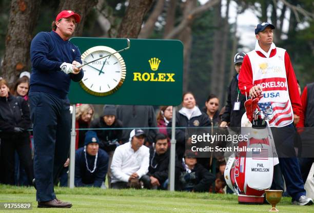 Phil Mickelson of the USA Team watches his tee shot on the ninth hole as his caddie Jim Mackay looks on during the Final Round Singles Matches of The...