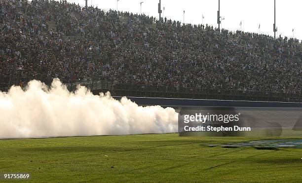 Jimmie Johnson, driver of the Lowe's Chevrolet, performs a burnout to celebrate winning the NASCAR Sprint Cup Series Pepsi 500 at Auto Club Speedway...