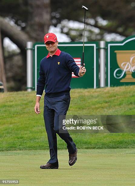 Team member Zach Johnson acknowledges the crowd after making his put on the 10th green during the final round singles matches at the Presidents Cup...