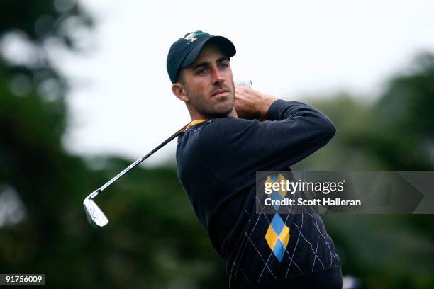 Geoff Ogilvy of the International Team watches his tee shot on the second hole during the Final Round Singles Matches of The Presidents Cup at...