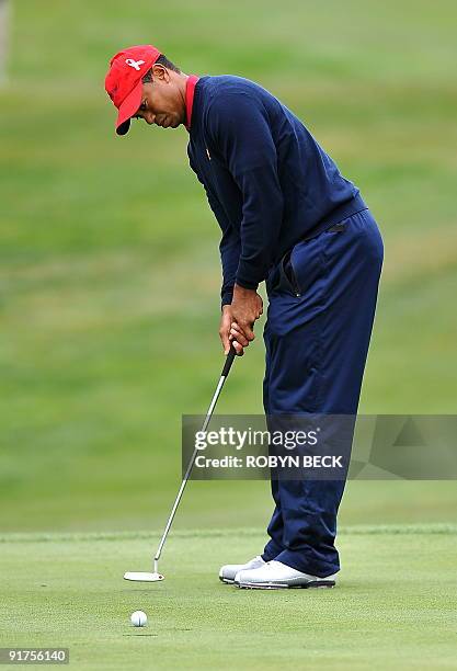 Team member Tiger Woods makes his final putt on the 13th green to win his match against Y.E. Yang of South Korea and clinch the Presidents Cup for...