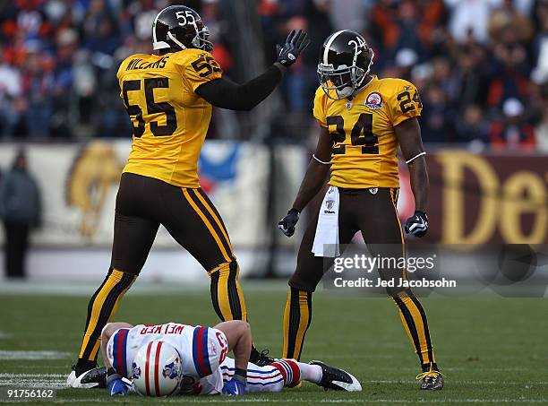 Wes Welker of the New England Patriots lies on the ground after missing a pass as Champ Bailey and D.J. Williams of the Denver Broncos look on during...