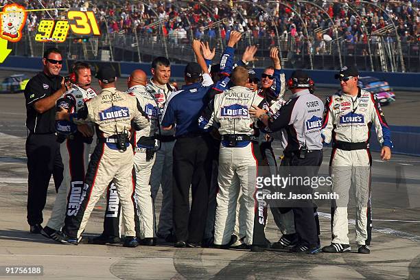 Crew members for Jimmie Johnson, driver of the Lowe's Chevrolet, celebrate on pit road after winning the NASCAR Sprint Cup Series Pepsi 500 at Auto...