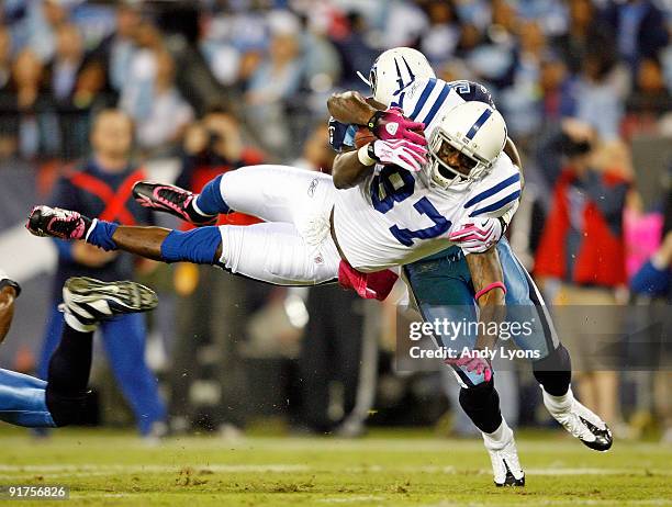 Reggie Wayne of the Indianapolis Colts is tackled by Jason McCourty of the Tennessee Titans during the NFL game at LP Field on October 11, 2009 in...