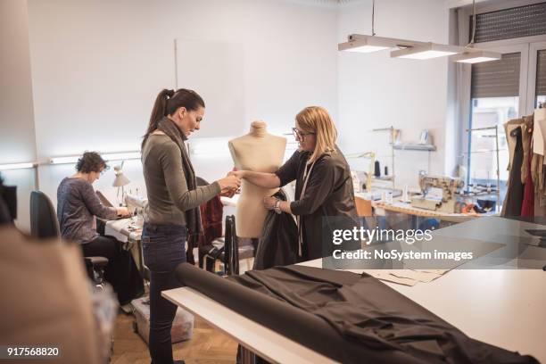 créatrice de mode féminine avec assistance au studio de design de mode - couture visible photos et images de collection
