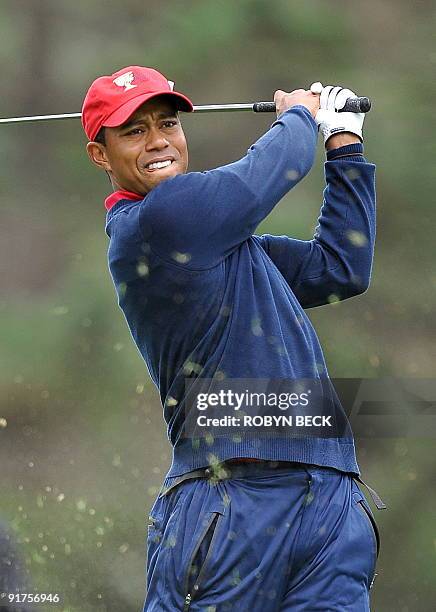 Turf flies in the air as US team member Tiger Woods tees off on the 12th hole during the final round singles matches of the Presidents Cup golf...