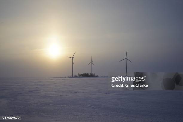 Wind turbine fans looms out of the fog near Oulu, North Finland
