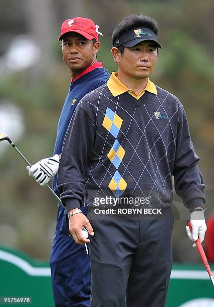 International team member Y.E. Yang of South Korea walks up to the 12th fee box after US team member Tiger Woods teed off during the final round...