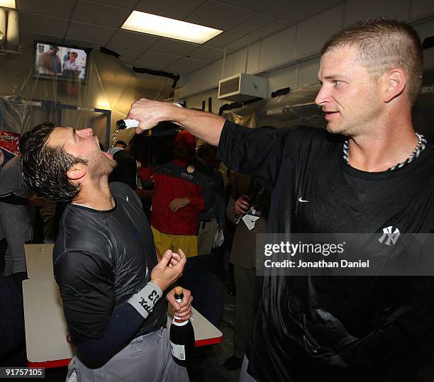 Burnett of the New York Yankees pours champagne into the mouth of Nick Swisher after a win over the Minnesota Twins in Game Three of the ALDS during...