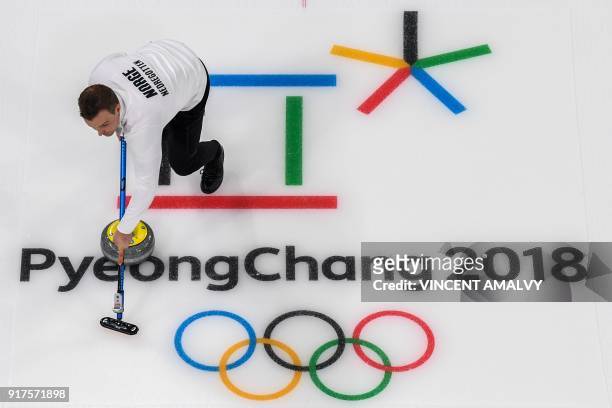 Norway's Magnus Nedregotten brushes the ice surface during the curling mixed doubles bronze medal game during the Pyeongchang 2018 Winter Olympic...