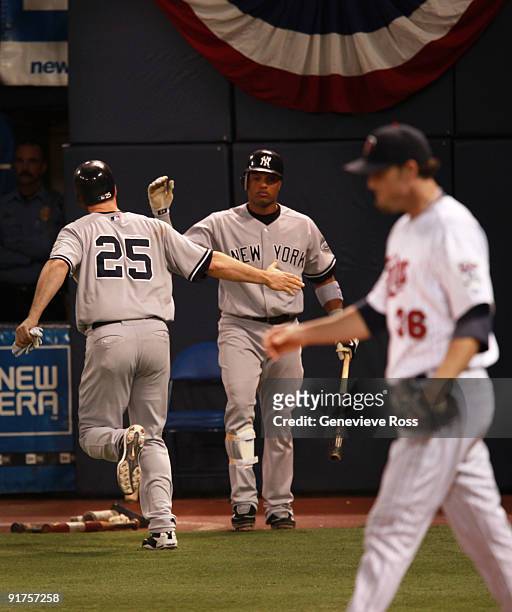 Mark Teixeira of the New York Yankees celebrates with teammate Robinson Cano after scoring a run against Joe Nathan of the Minnesota Twins in the...