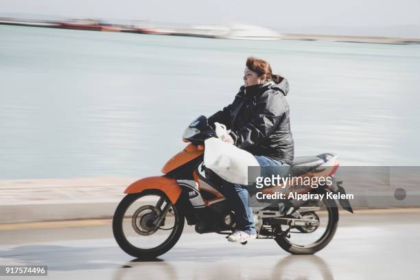 les femmes conduire la moto sur la rue de la ville de pyrgi dans l’île de chios en grèce - pyrgi photos et images de collection