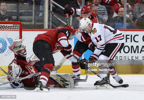 Lance Bouma of the Chicago Blackhawks battles with Brad Richardson and Oliver Ekman-Larsson of the Arizona Coyotes for a loose puck in front of...