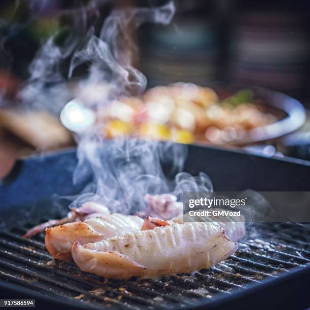 preparing fresh squid on a grill pan - cuttlefish stock pictures, royalty-free photos & images