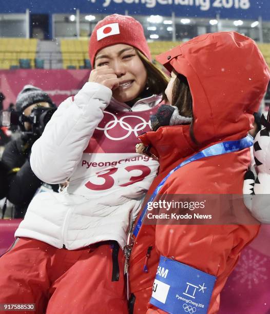 Sara Takanashi of Japan bursts into tears in the arms of her coach Izumi Yamada after winning the bronze medal in the women's normal hill individual...