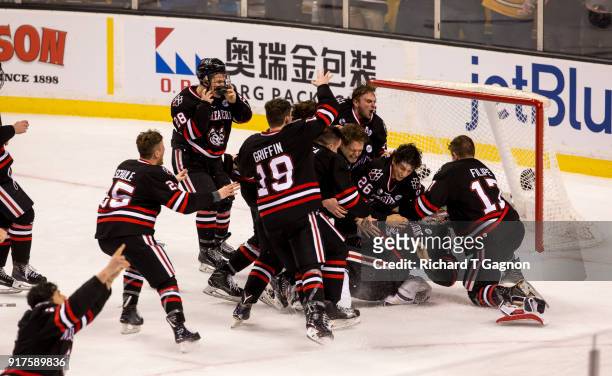 Cayden Primeau of the Northeastern Huskies celebrates with his teammates Eric Williams, Matt Filipe and Biagio Lerario after a game against the...