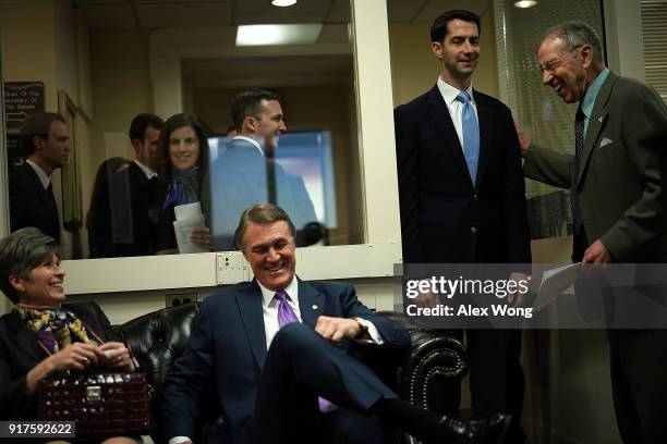 Sens. Chuck Grassley , Tom Cotton , David Perdue and Joni Ernst share a moment prior to a news conference on immigration February 12, 2018 at the...