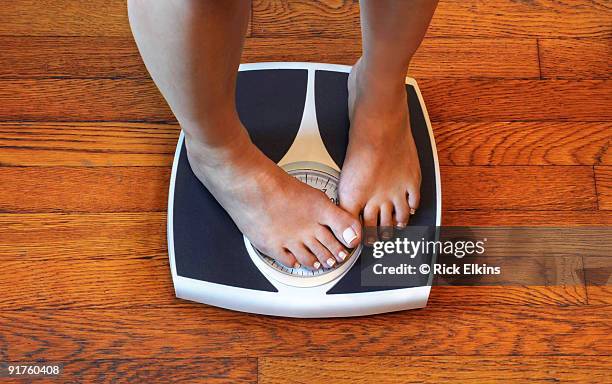 woman on scale unhappy with her weight - preocupación por el cuerpo fotografías e imágenes de stock