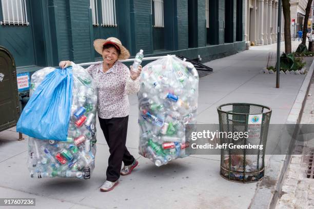 An Asian woman with bags of recycling aluminum cans.