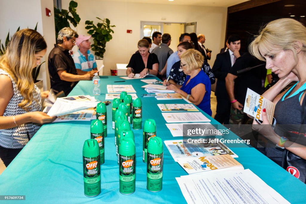 A woman looking at the free mosquito spray OFF! Being given out at the Zika Virus Town Hall Meeting at Waverly Condominiums.