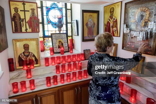 Woman touching an icon inside the St Nicholas Greek Orthodox Cathedral.