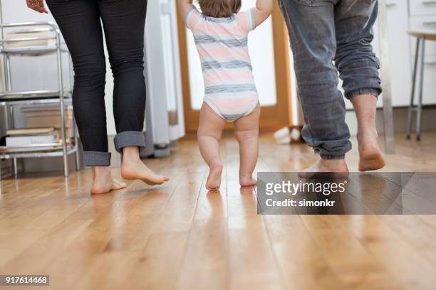 baby jongen nemen eerste stappen - boy barefoot rear view stockfoto's en -beelden
