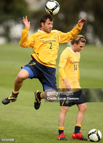 Lucas Neill of the Socceroos heads the ball at an Australian Socceroos training session at Monash University on October 12, 2009 in Melbourne,...