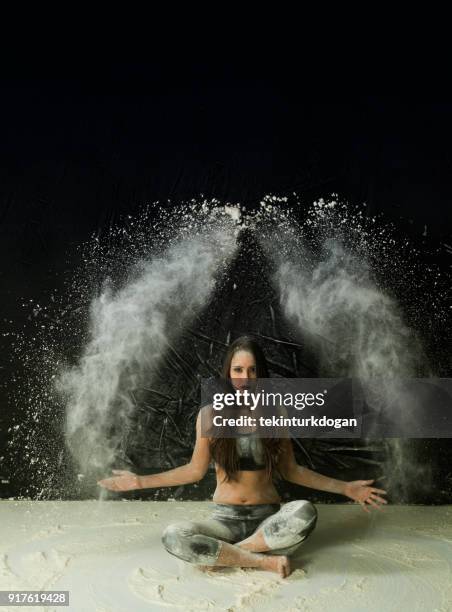 jonge vrouw poseren in stof en poeder in studio in istanboel - angel dust stockfoto's en -beelden