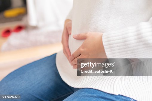 Pregnant woman touching abdomen Pregnant woman touching abdomen