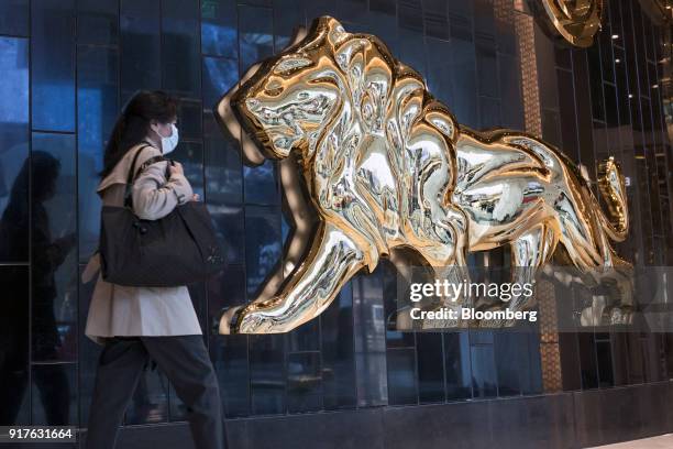 Pedestrian walks past signage for the MGM Cotai casino resort, developed by MGM China Holdings Ltd., outside the casino resort in Macau, China, on...