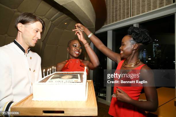 Actress Danai Gurira blows out the candles on her birthday cake as Lupita Nyong'o looks on during the DANAI x One x Love Our Girls celebration at The...