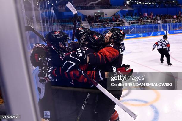 Canada's players celebrate after scoring during the first period of the women's preliminary round ice hockey match between Canada and Finland during...