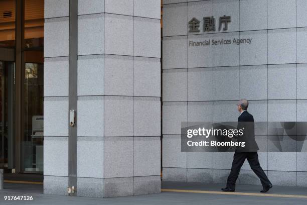 Pedestrian walks past the Financial Services Agency headquarters in Tokyo, Japan, on Tuesday, Feb. 13, 2018. Cryptocurrency exchange Coincheck inc.,...