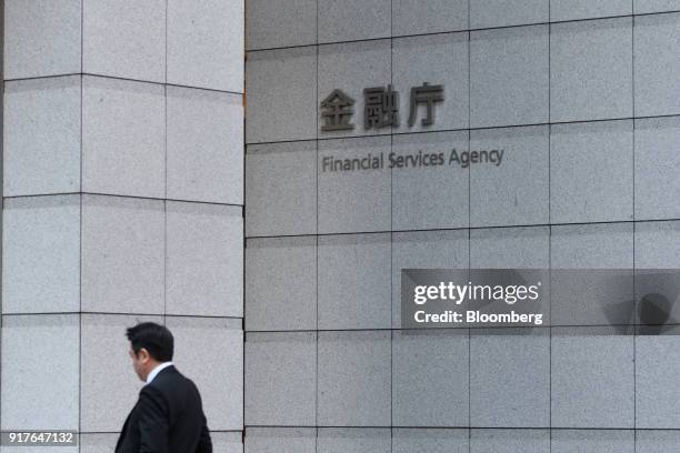 Pedestrian walks past the Financial Services Agency headquarters in Tokyo, Japan, on Tuesday, Feb. 13, 2018. Cryptocurrency exchange Coincheck Inc.,...