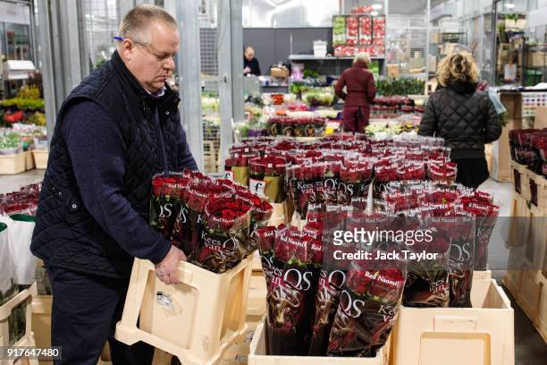Trader lifts a box of roses at New Covent Garden Flower Market ahead of Valentine's Day on February 13, 2018 in London, England. New Covent Garden...