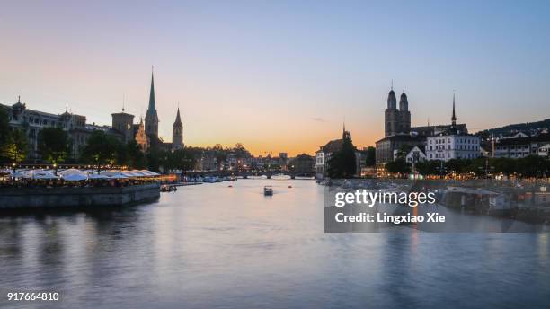 zurich city skyline with limmat river at dusk, switzerland - grossmünster stock-fotos und bilder