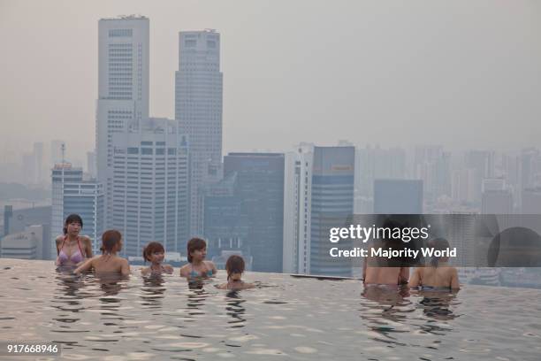 Guests relax at the Infinity Pool at the famous Marina Bay Sands Hotel SkyPark, Singapore.