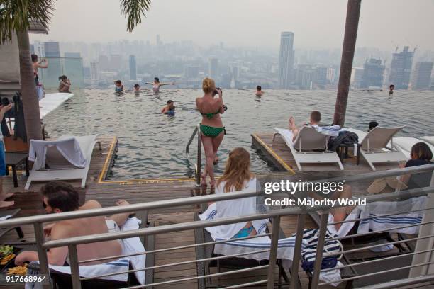 Guests relax at the Infinity Pool at the famous Marina Bay Sands Hotel SkyPark, Singapore.