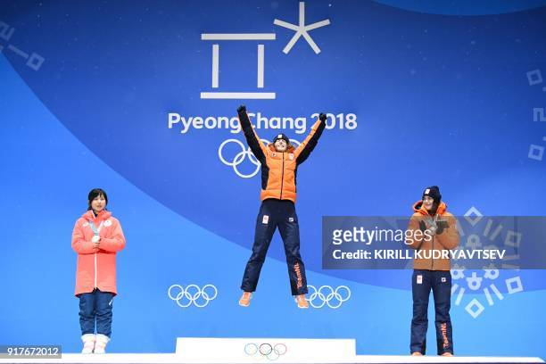 Netherlands' gold medallist Ireen Wust jumps on the podium between Japan's silver medallist Miho Takagi and Netherlands' bronze medallist Marrit...