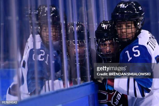 Finland's Minnamari Tuominen pins Canada's Jillian Saulnier against the glass during the final period of the women's preliminary round ice hockey...