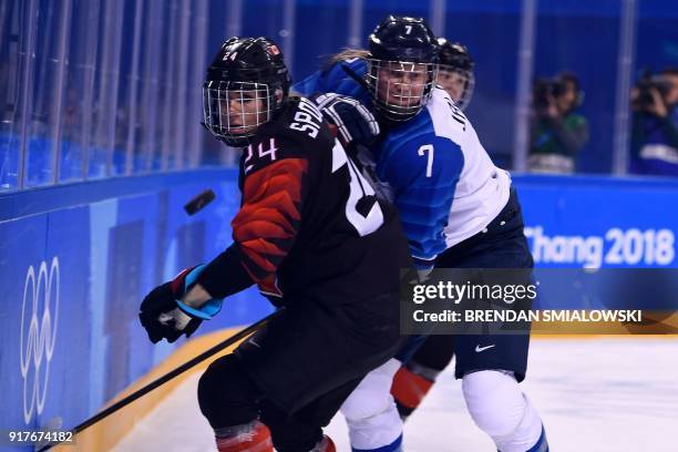 Canada's Natalie Spooner and Finland's Mira Jalosuo fights for the puck during the final period of the women's preliminary round ice hockey match...