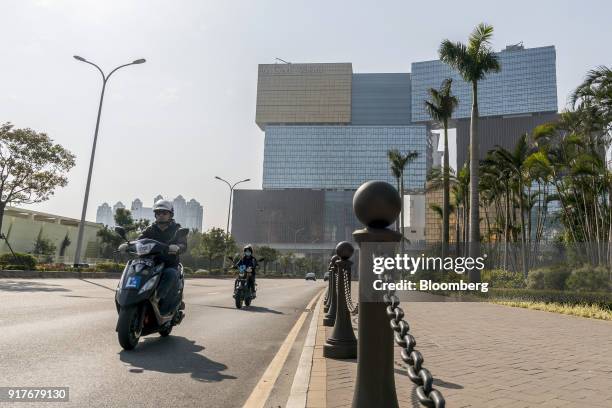 Motorcyclists ride on scooters as the MGM Cotai casino resort, developed by MGM China Holdings Ltd., stands in the background in Macau, China, on...