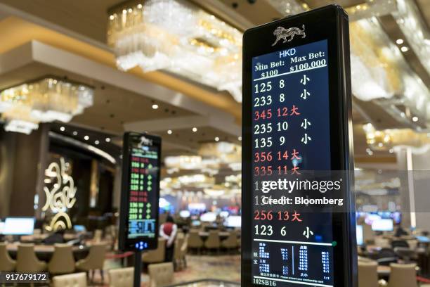 An electronic monitor displays betting information near blackjack tables on the gaming floor of the casino at the MGM Cotai casino resort, developed...