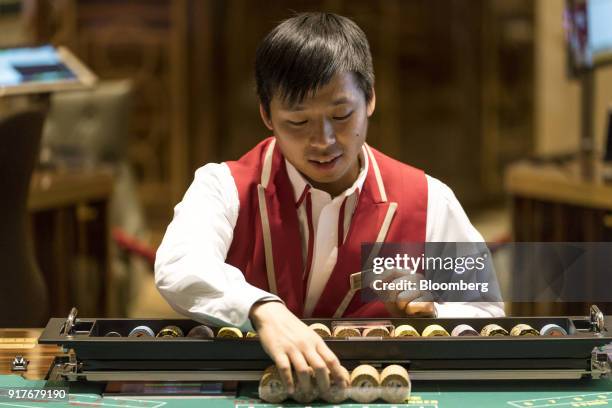Dealer handles gaming chips on the floor of the casino at the MGM Cotai casino resort, developed by MGM China Holdings Ltd., in Macau, China, on...