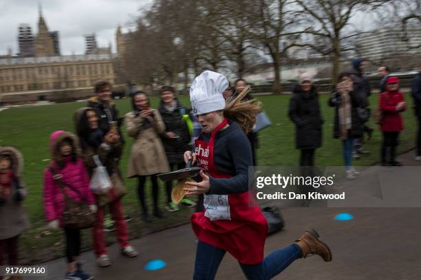 Competitor runs the first lap during the annual Parliamentary Pancake Race in Victoria Tower Gardens on Shrove Tuesday on February 13, 2018 in...