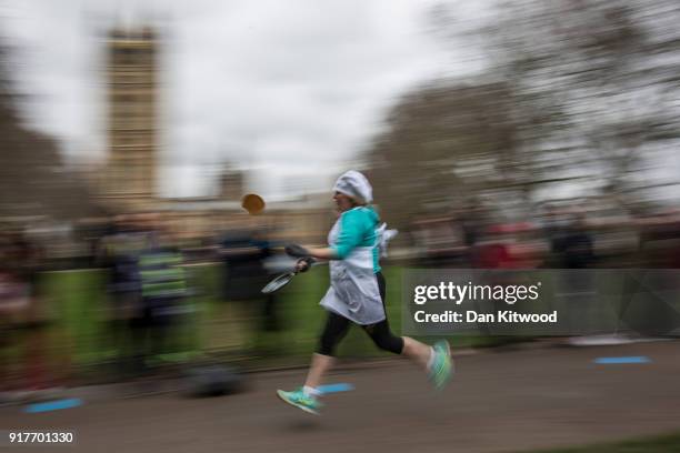 Competitor runs a lap during the annual Parliamentary Pancake Race in Victoria Tower Gardens on Shrove Tuesday on February 13, 2018 in London,...