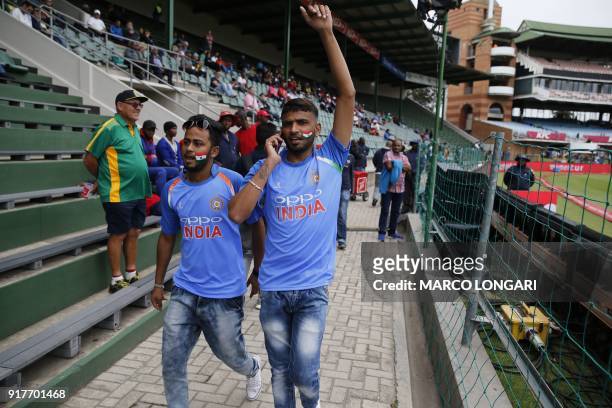 Indian supporters walk past activists waving the flag of Pakistan-administered Kashmir at the beginning of the fifth One-Day International cricket...
