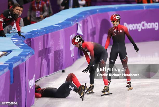 Charles Hamelin of Canada and Charle Cournoyer of Canada go to teammate Samuel Girard of Canada after his crash during the Men's 5000m Relay Short...