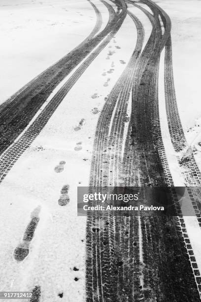 tire tracks and footprints in the snow - alexandra pavlova foto e immagini stock