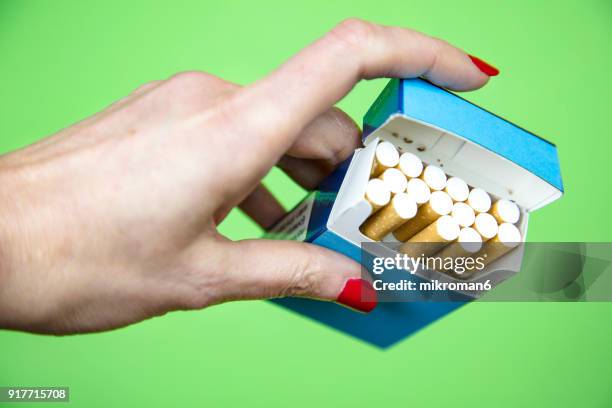 woman's hand taking cigarette from pack - zigarettenfilter stock-fotos und bilder